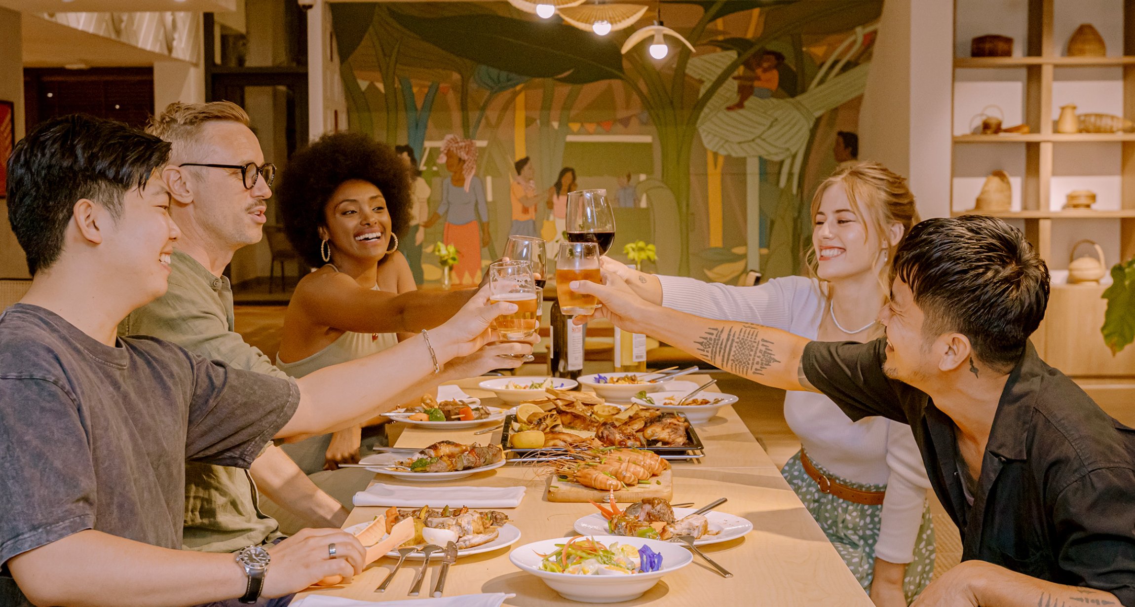 Housemates raising a toast around the long table