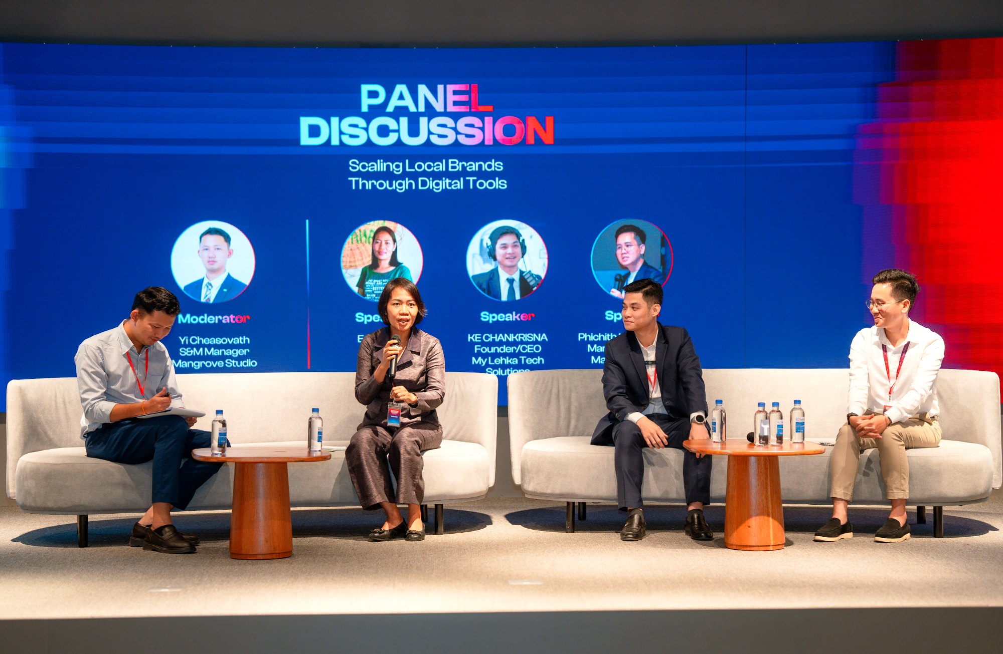 A panel discussion on the Commune auditorium stage, speakers on sofas in front of the LED screen