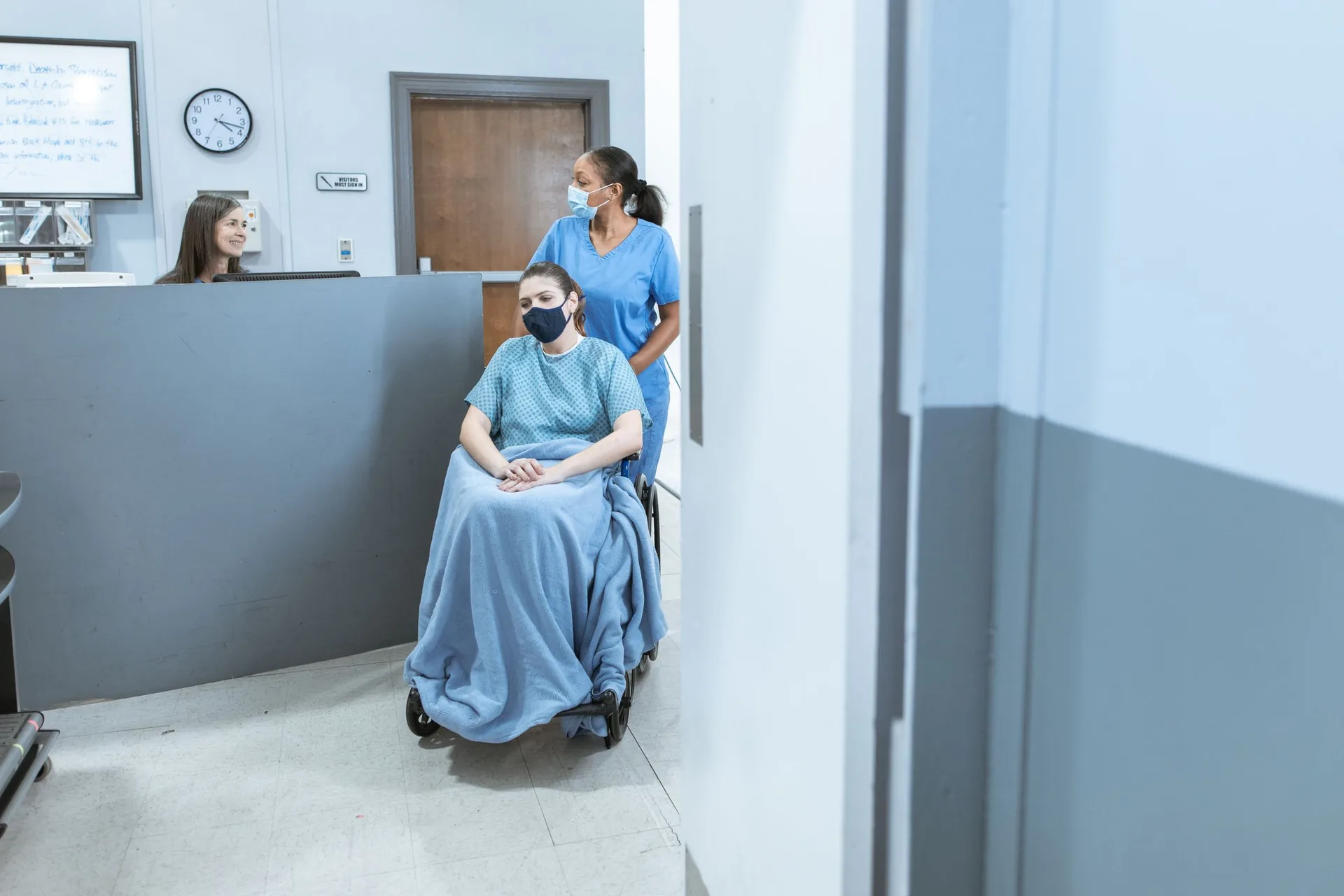 Nurse helping a wheelchair user at a step-free clinic reception