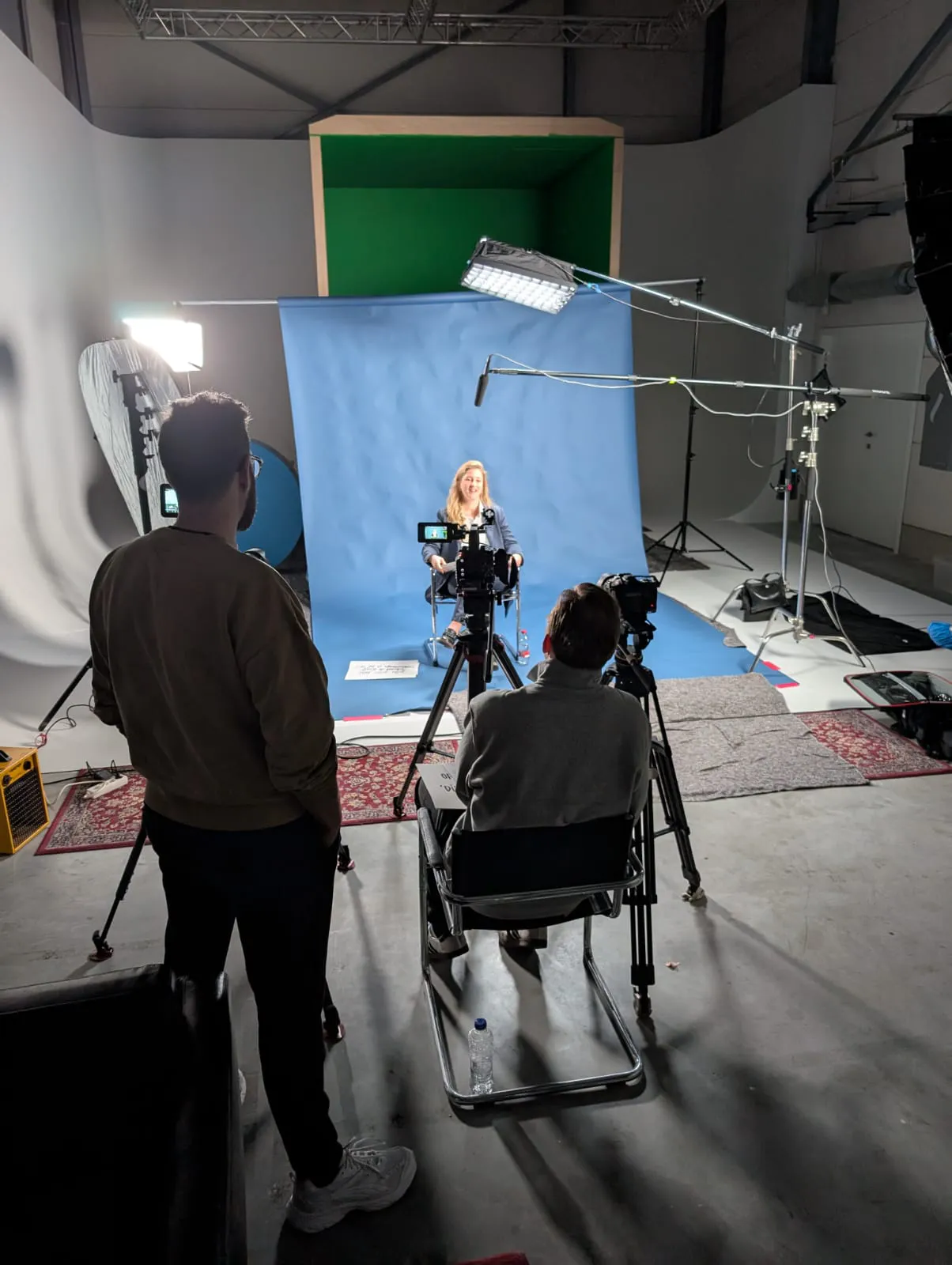 Studio-opstelling testimonialvideo IBR: twee camera's en crew voor een blauwe achtergrond