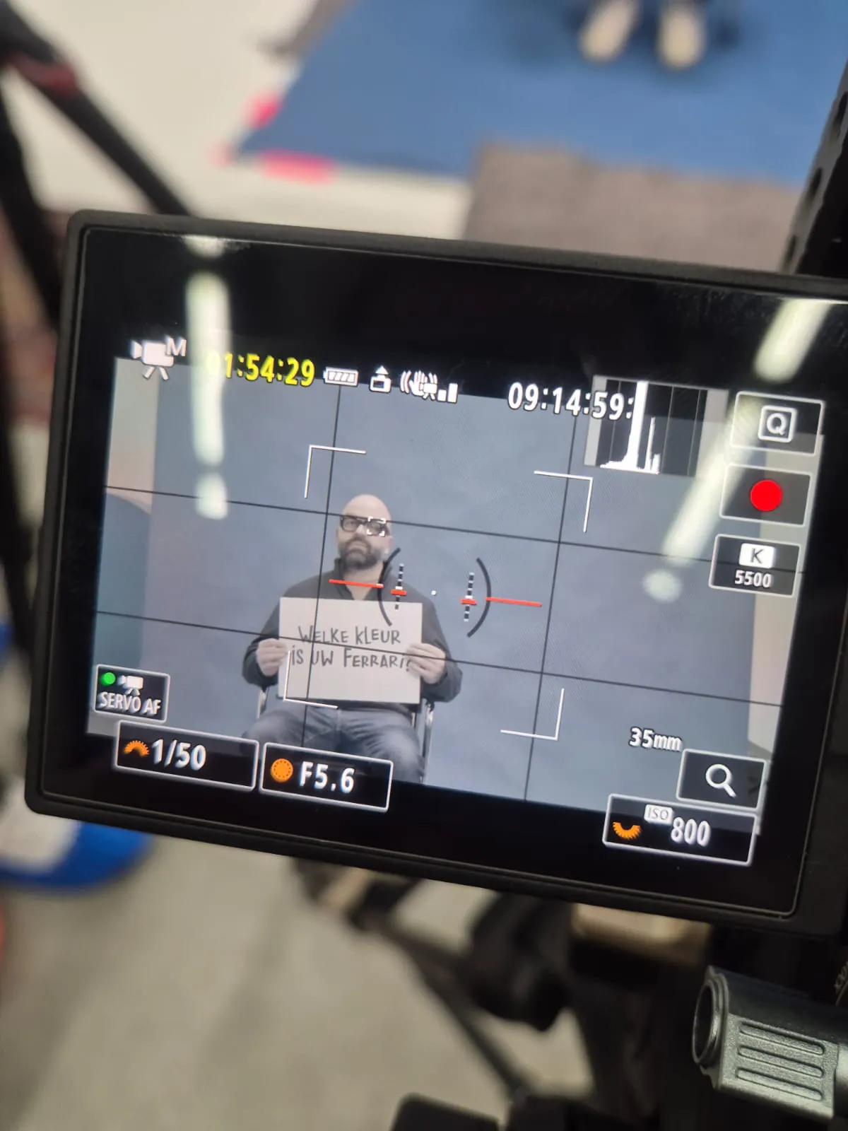 Testimonialvideo IBR: cameraschermbeeld van man met bordje 'Welke kleur is uw Ferrari?'