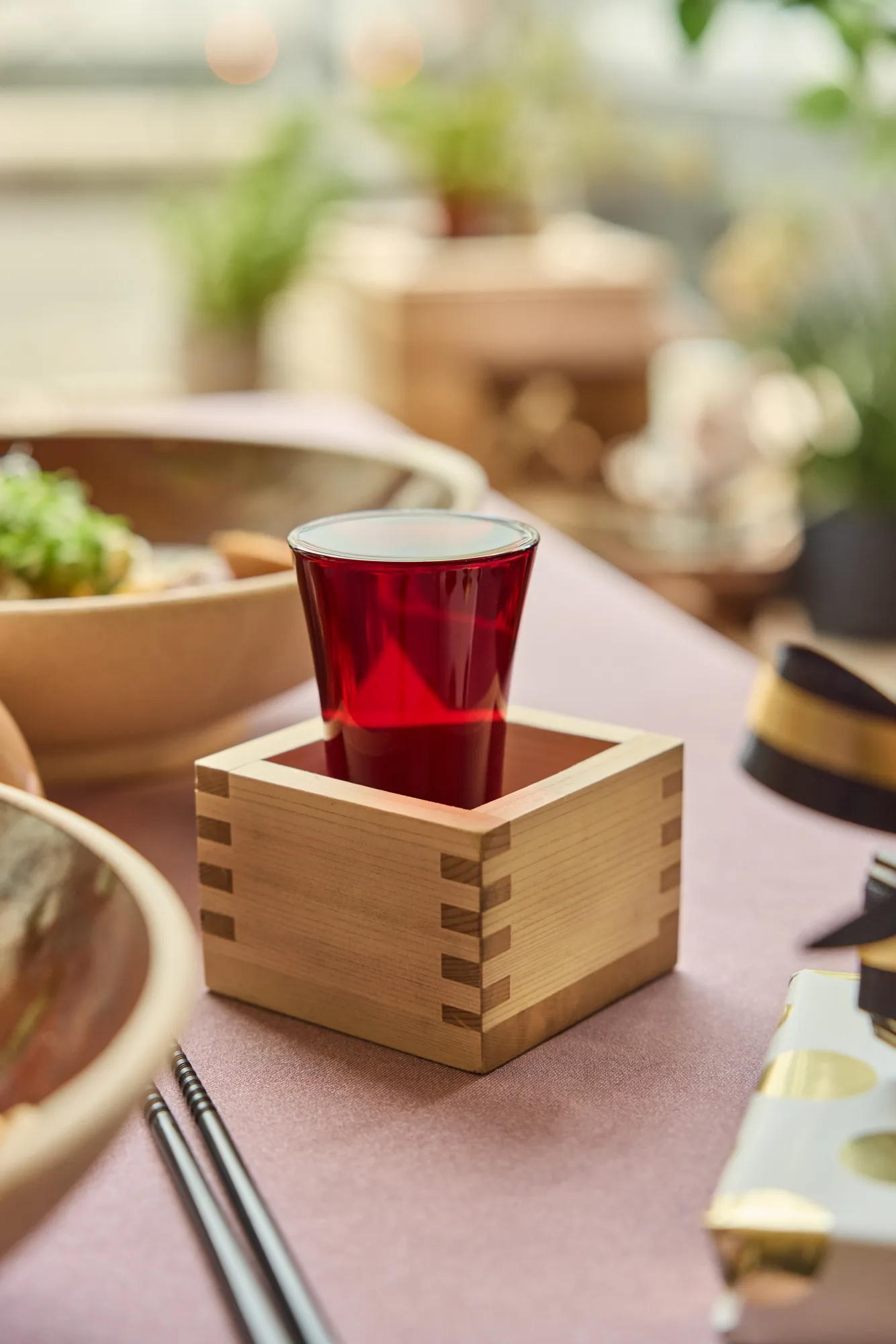 Foodfotografie Zuru Zuru Ramen: rode drank in een houten masu op een roze tafel