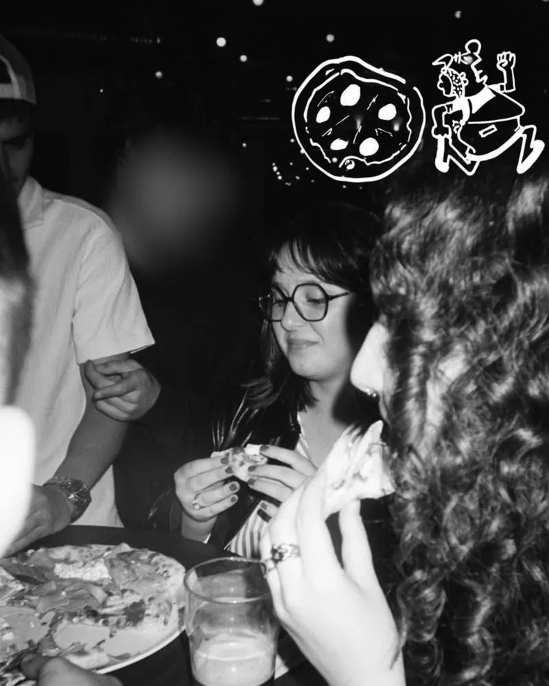 Moment partagé autour d'une pizza avec l'équipe d'un client, en noir et blanc