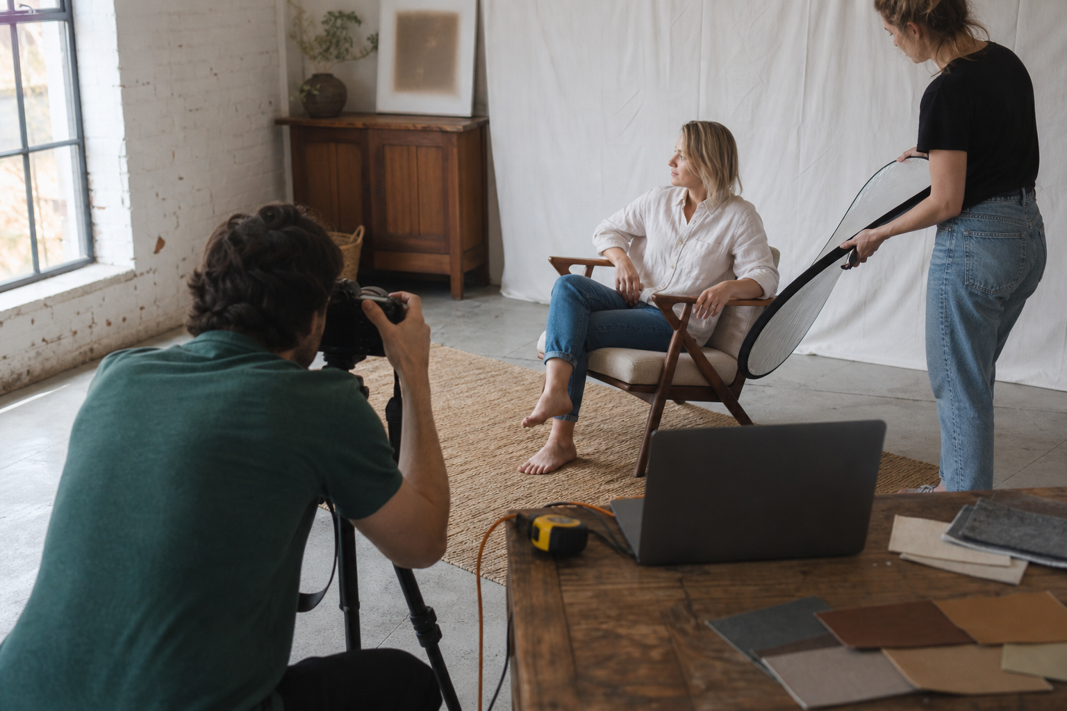 Un equipo de contenido fotografía a una persona sentada de forma natural en un sillón, en un estudio con luz de día.