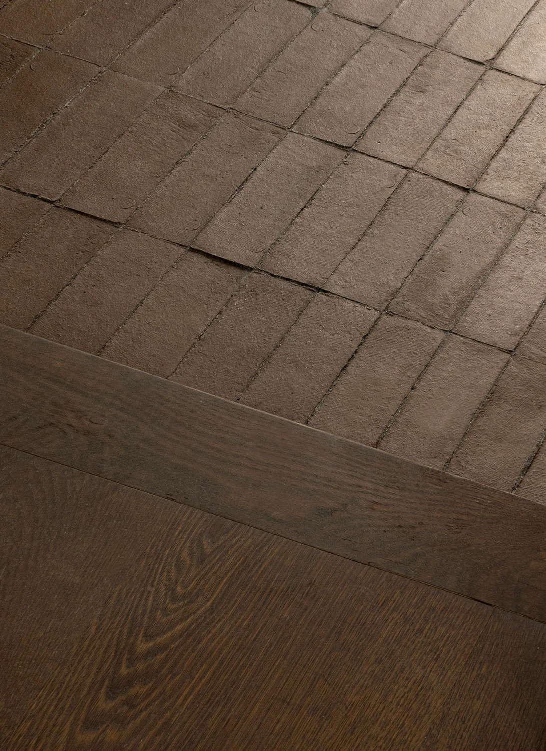 Brick flooring meeting dark timber at Norm Architects’ Copenhagen studio.