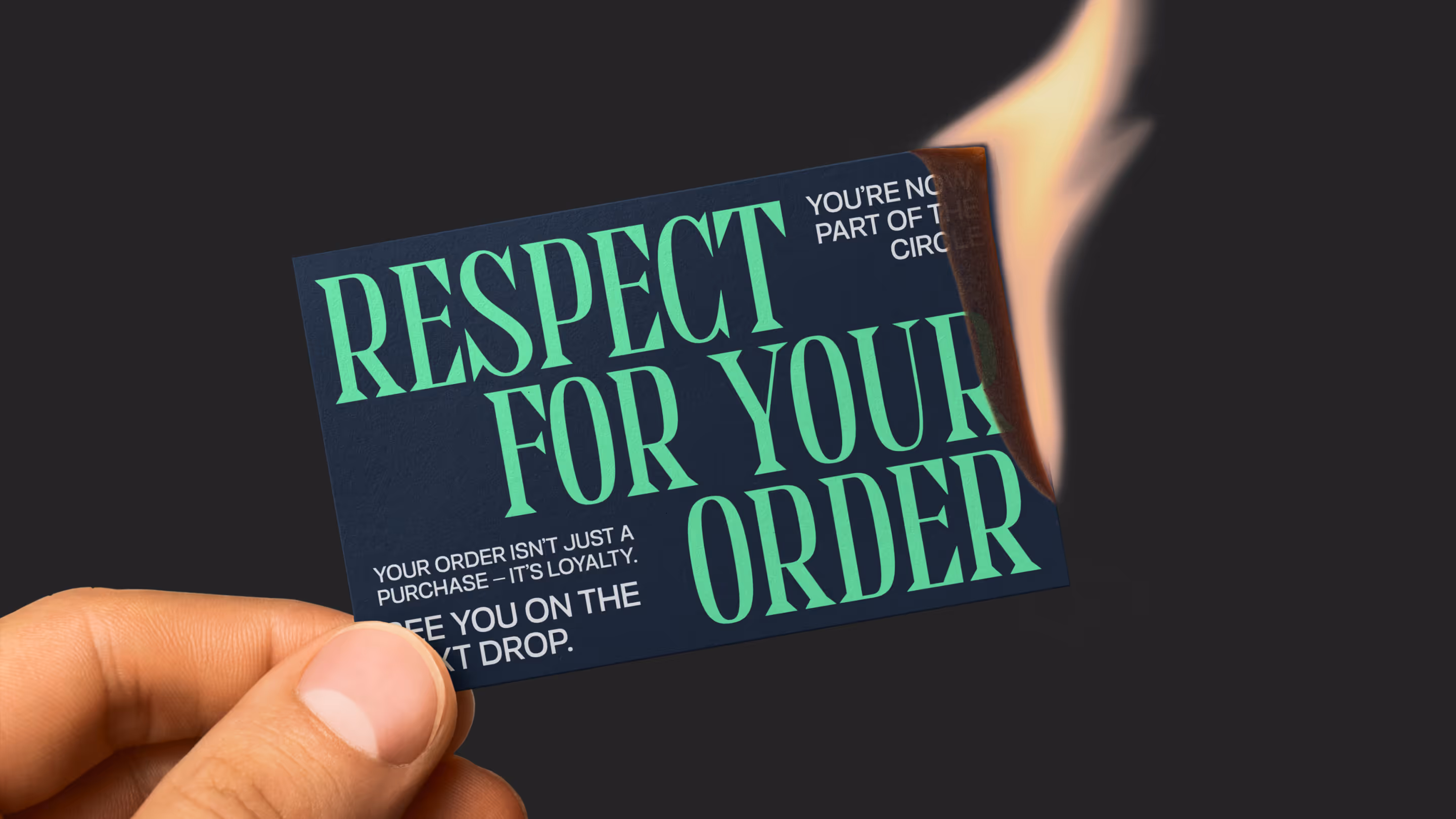 A hand holding a dark card with the text 'Respect for your order' partially burning on the top right corner.