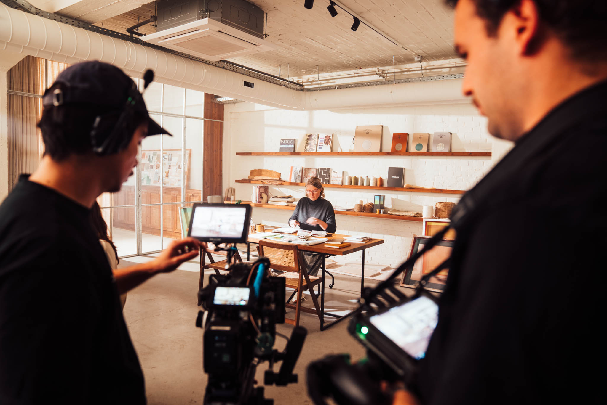 Majortale crew filming a woman at a desk in a styled studio