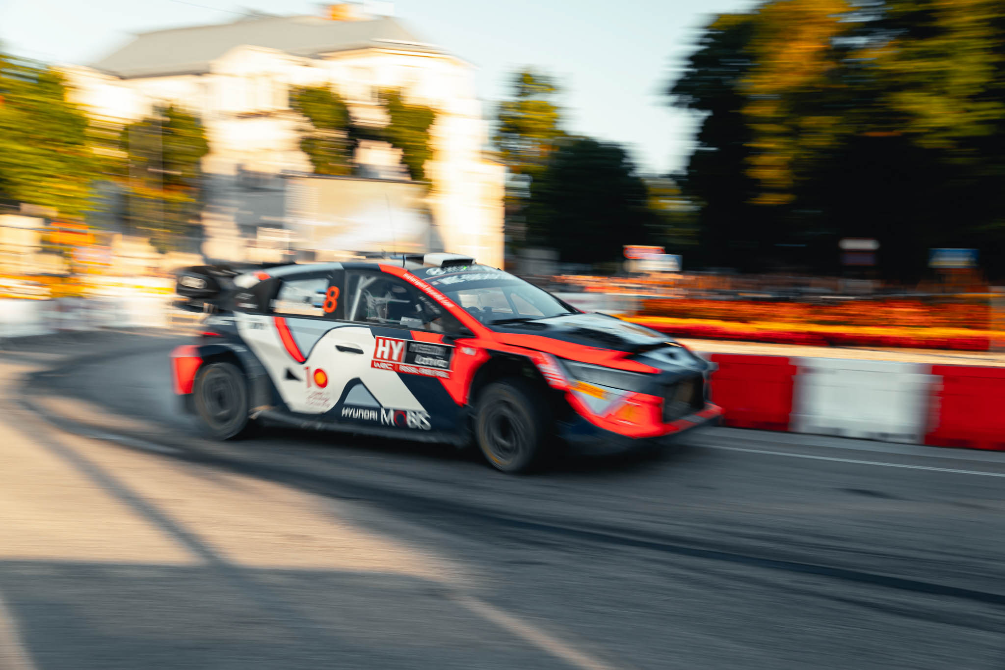 Hyundai rally car speeding through a city street stage