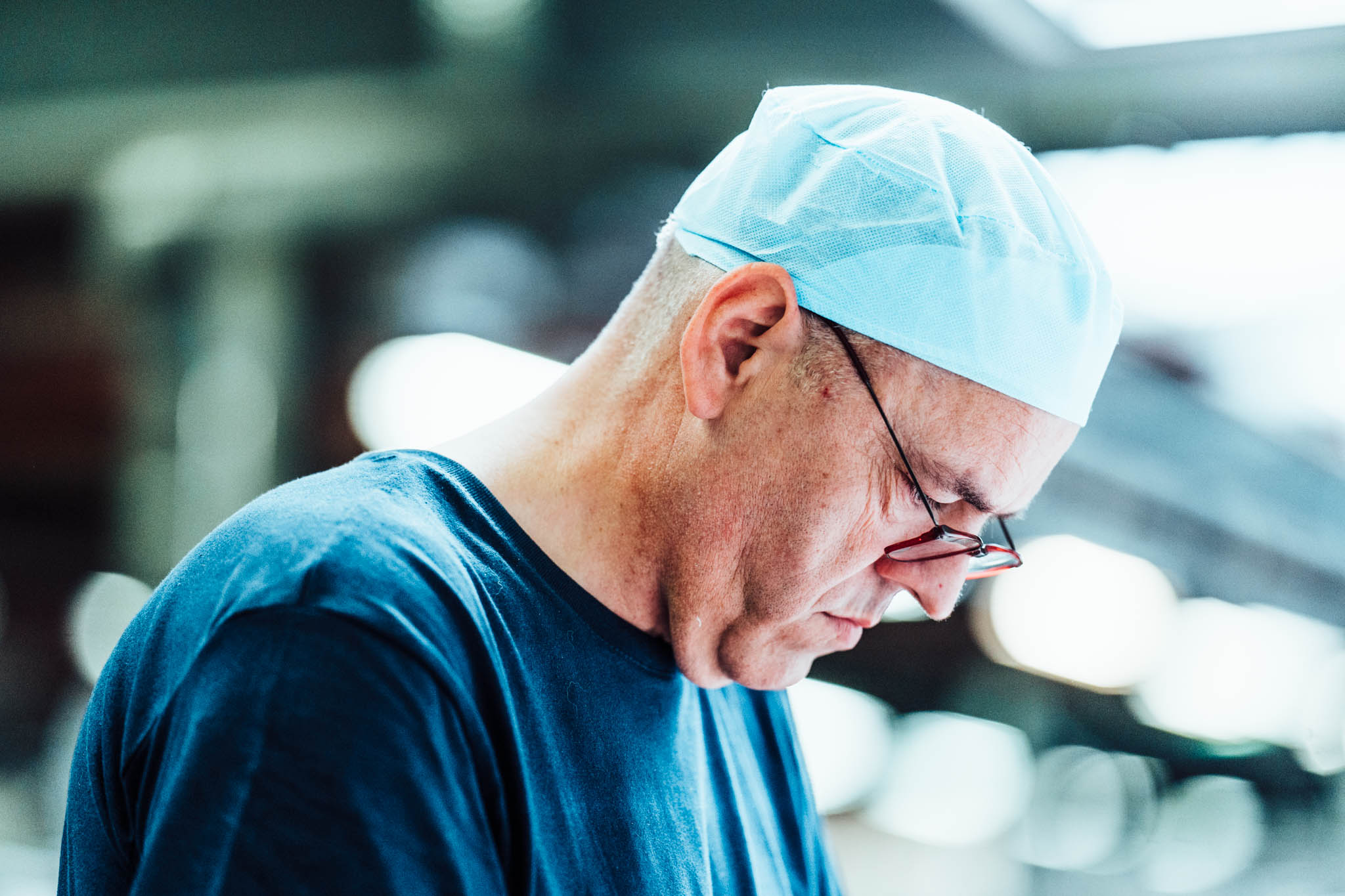 Factory worker in a hair net focused on his task