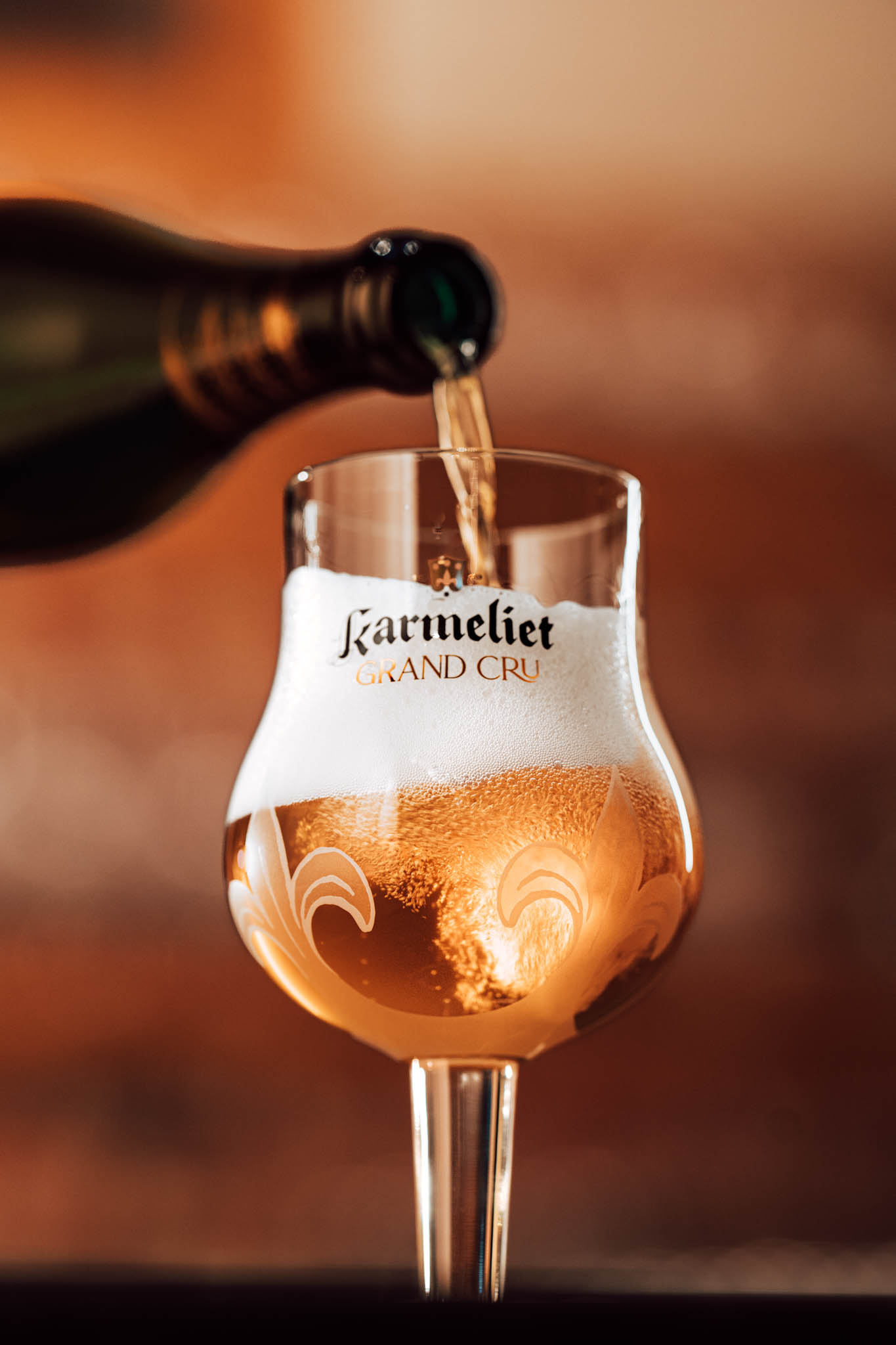 Karmeliet Grand Cru being poured into a branded glass