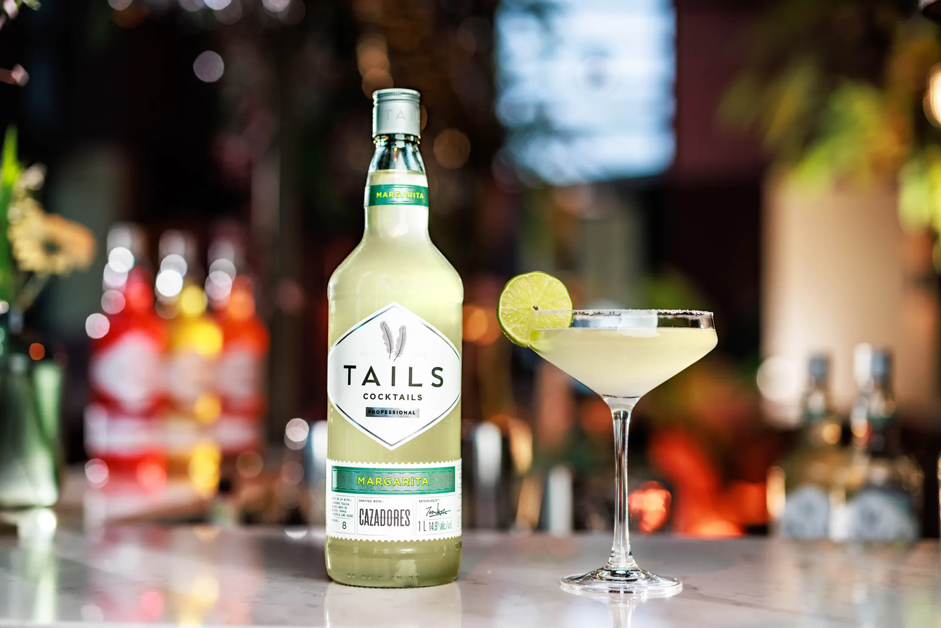 Tails margarita cocktail bottle and glass on a bar