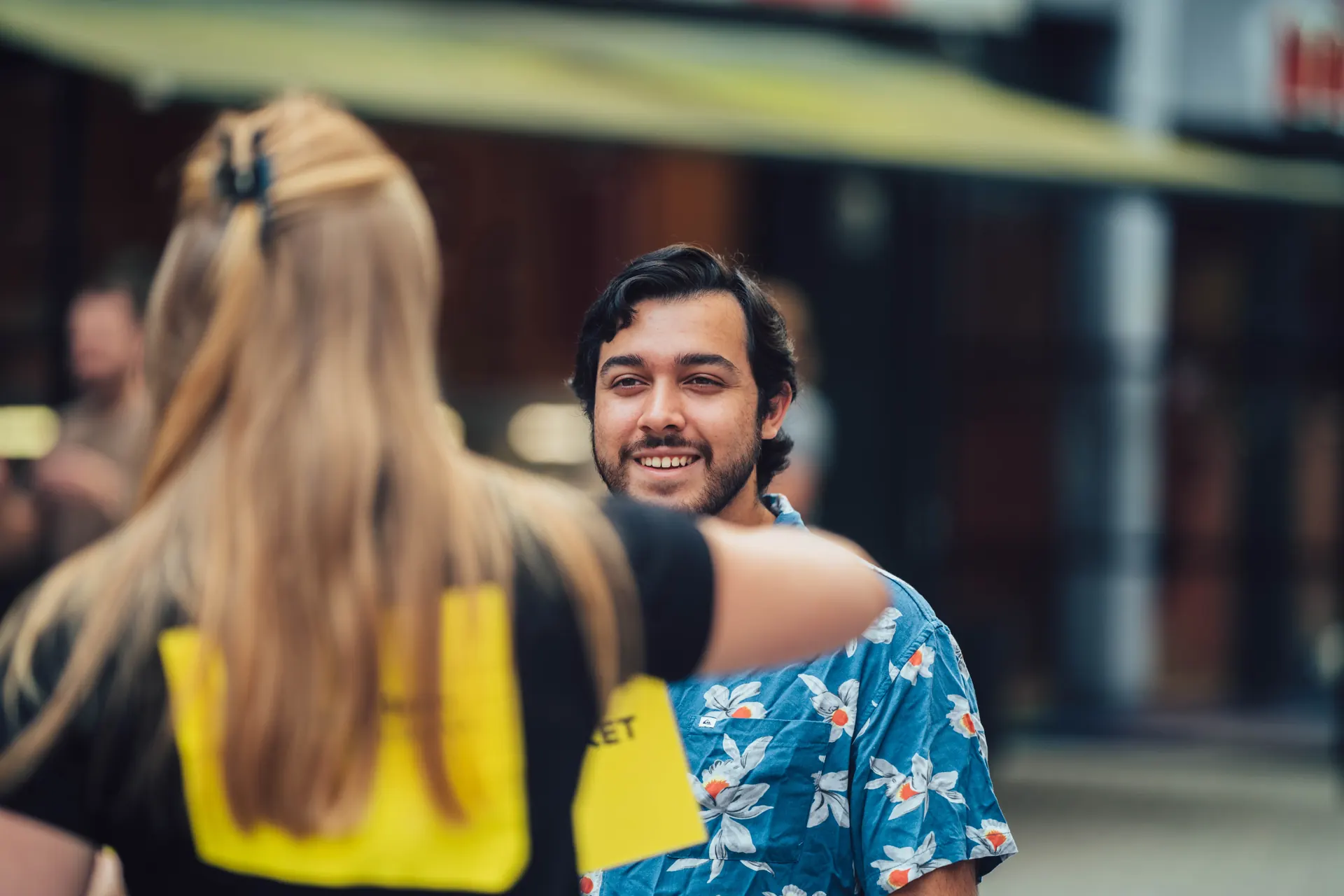 Presenter talking with a smiling passer-by during a street interview