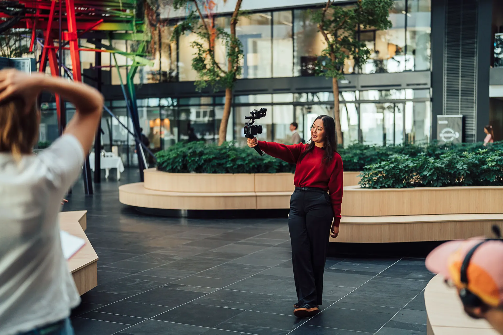 Woman filming herself with a selfie rig in an office atrium