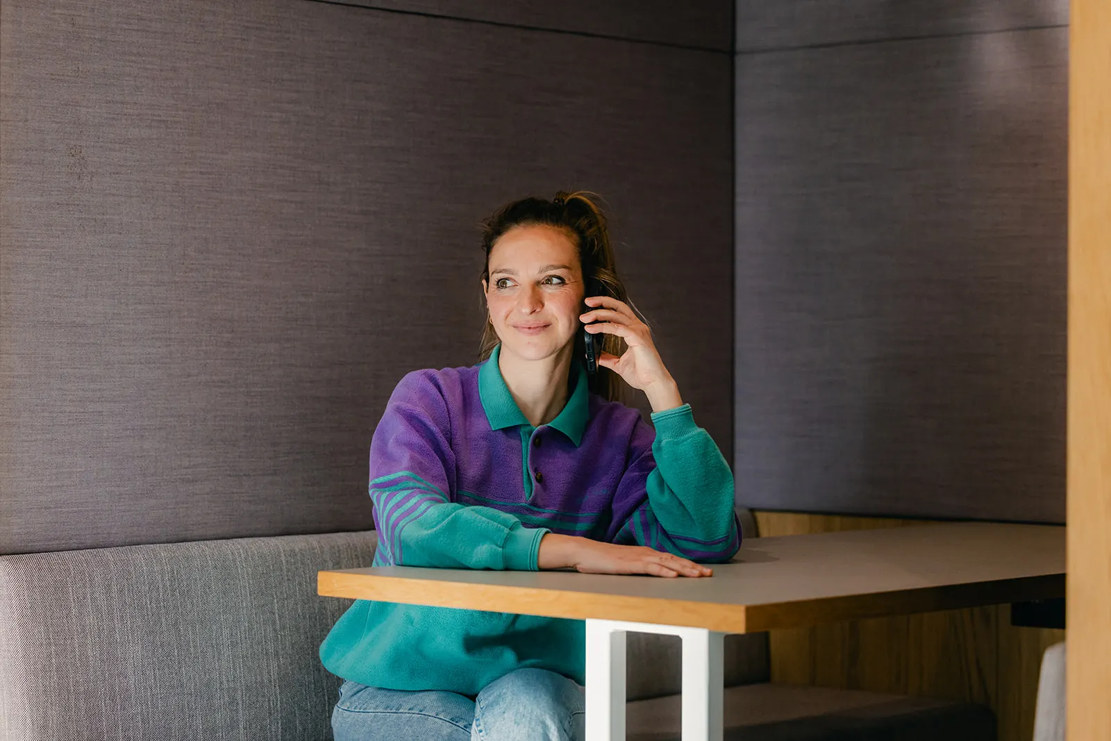 Woman on the phone in an office booth, scene from the Eneco campaign