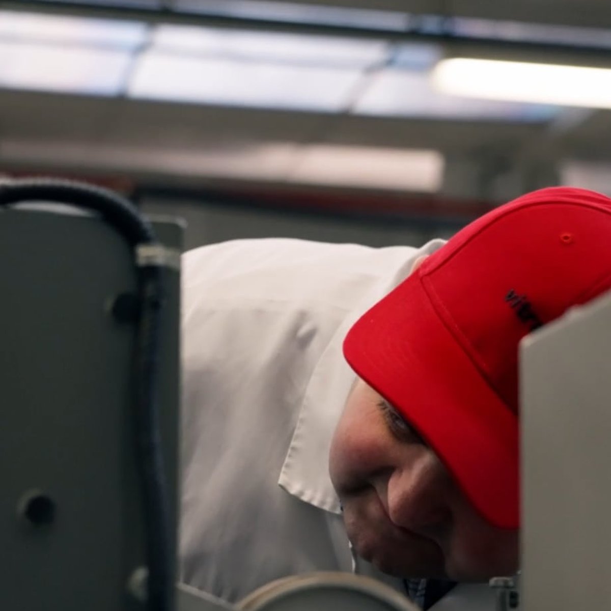 VitraPack operator in a red cap working at a machine