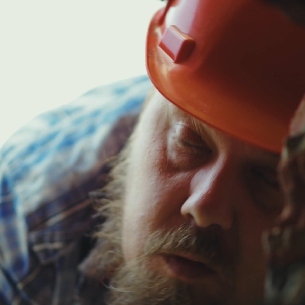 Construction worker in an orange helmet leaning in, from the Vivaldis campaign film