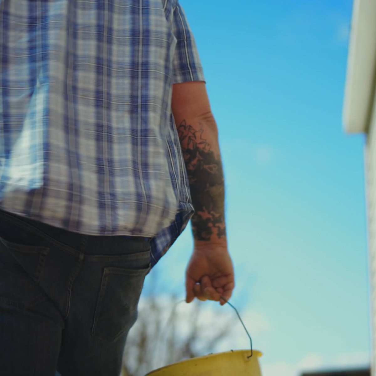 Construction worker carrying a yellow bucket on site