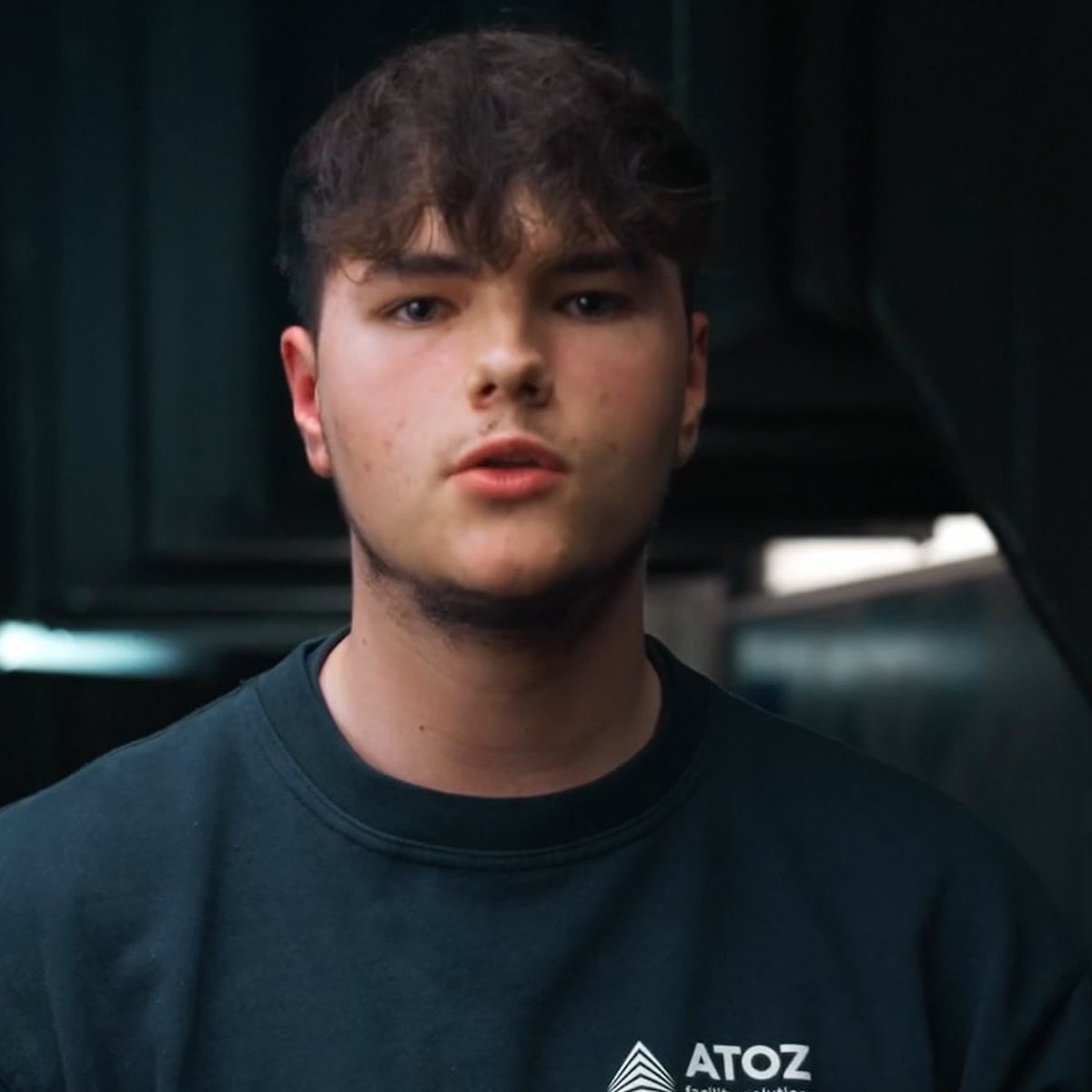 Young ATOZ technician in a branded sweater looking into the camera