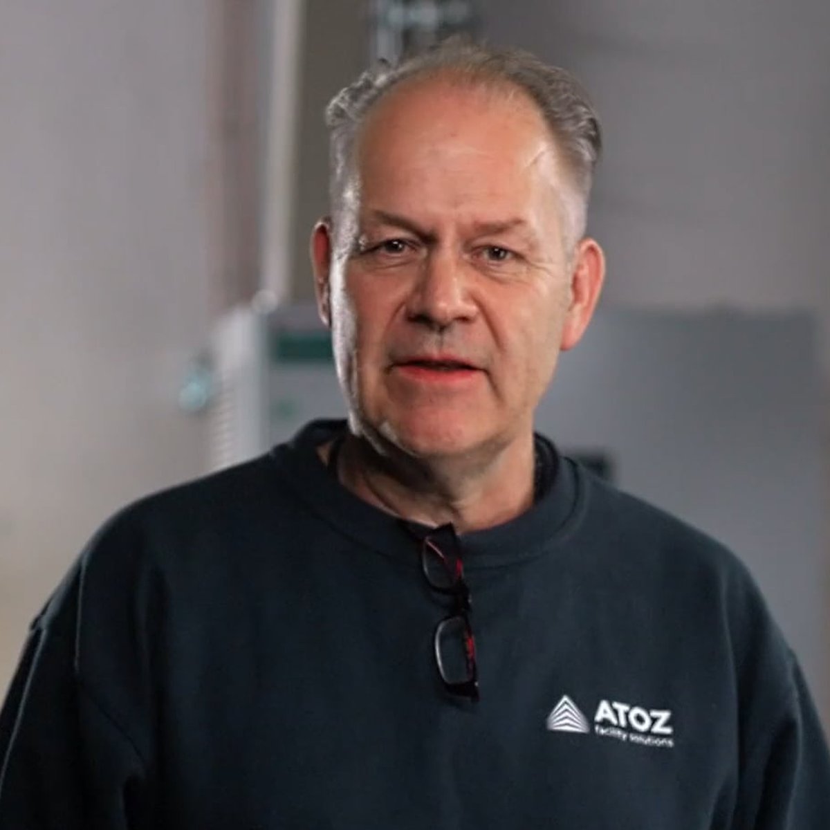 Experienced ATOZ technician in a branded sweater talking to the camera
