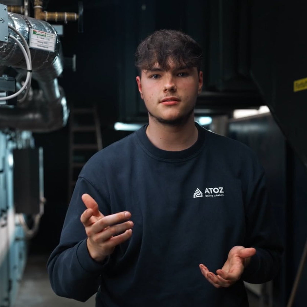 Young ATOZ technician explaining his job in a plant room