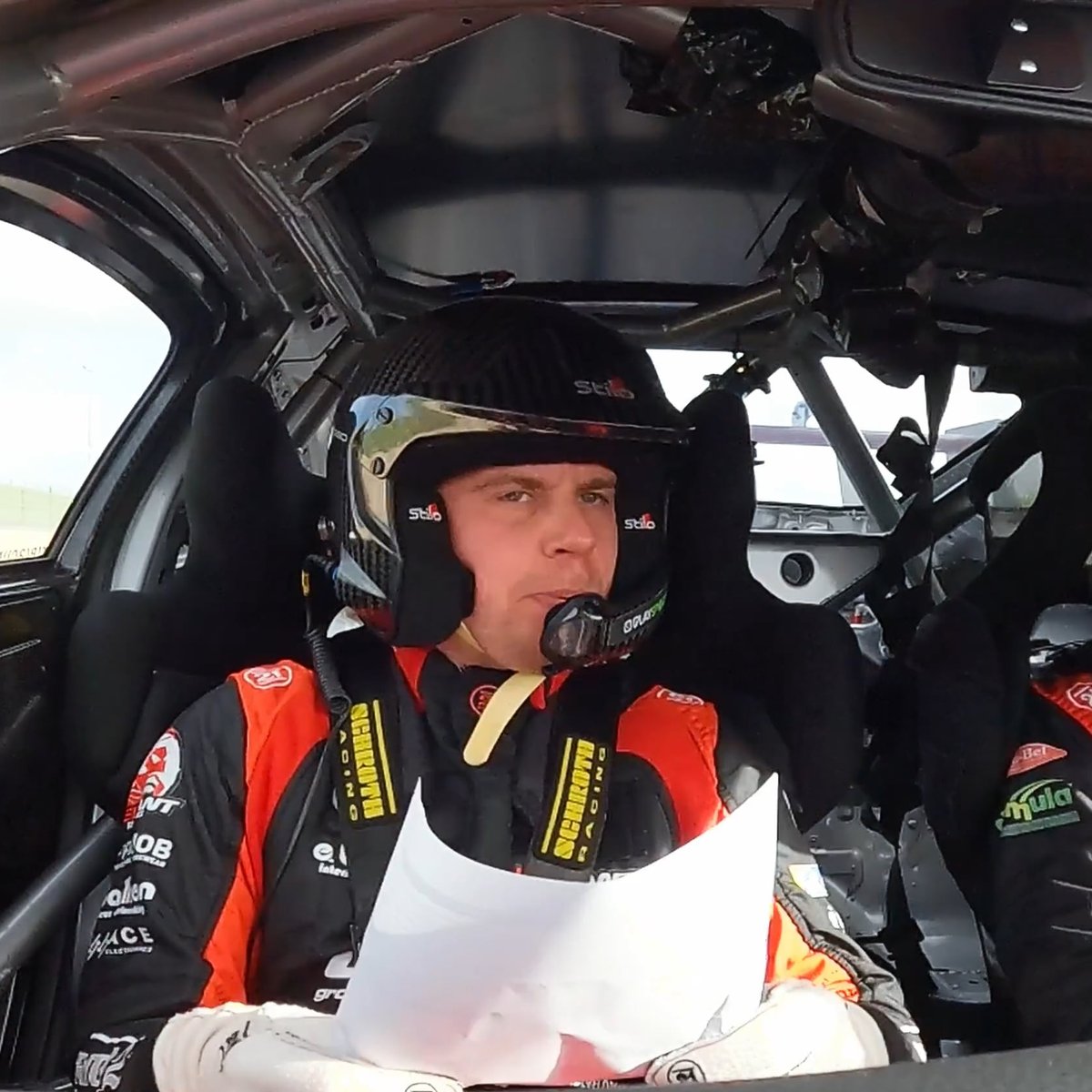 Driver in a helmet reading notes in the cockpit