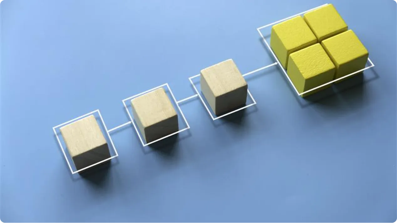 Four beige cubes connected in a line to a cluster of four yellow cubes on a blue surface.