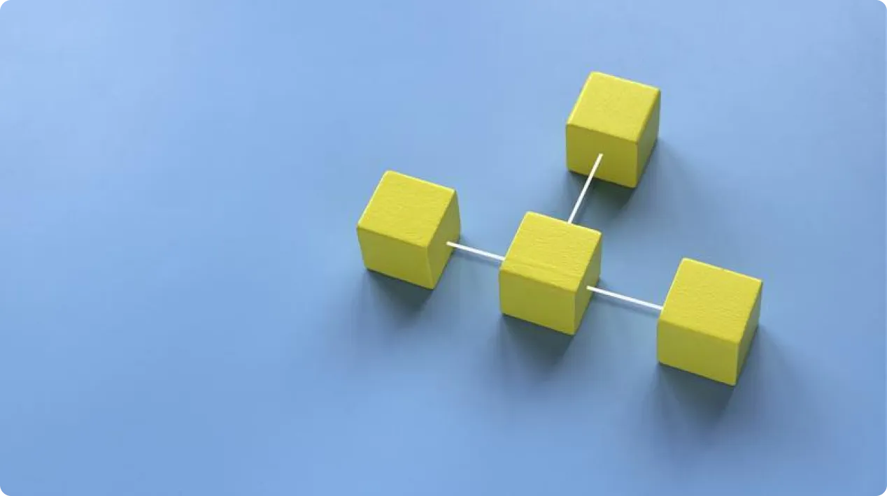 Four yellow cubes connected by white rods forming a network on a blue surface.