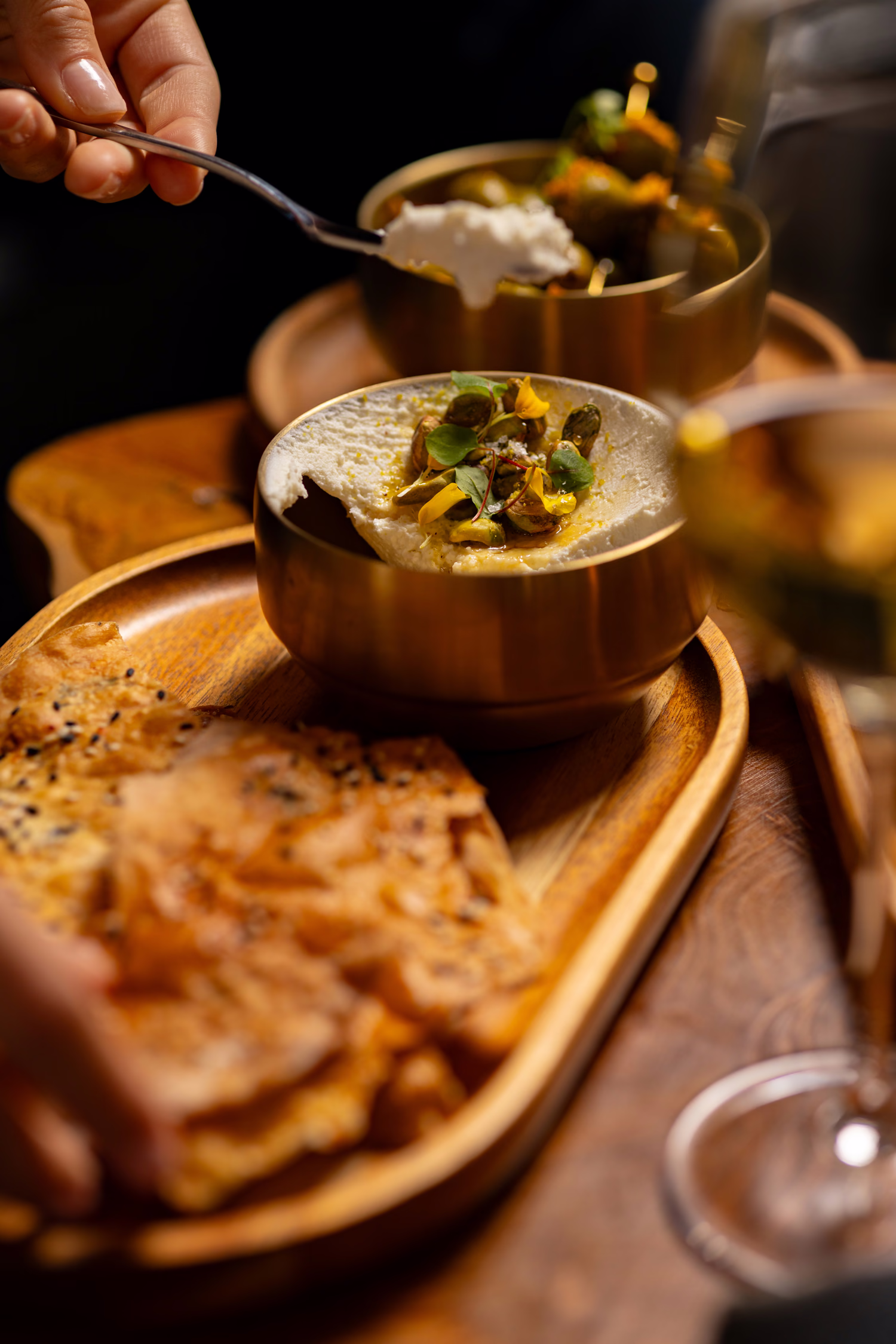 Dips in brass bowls with flatbread on a wooden tray at Mountain Top Lodge