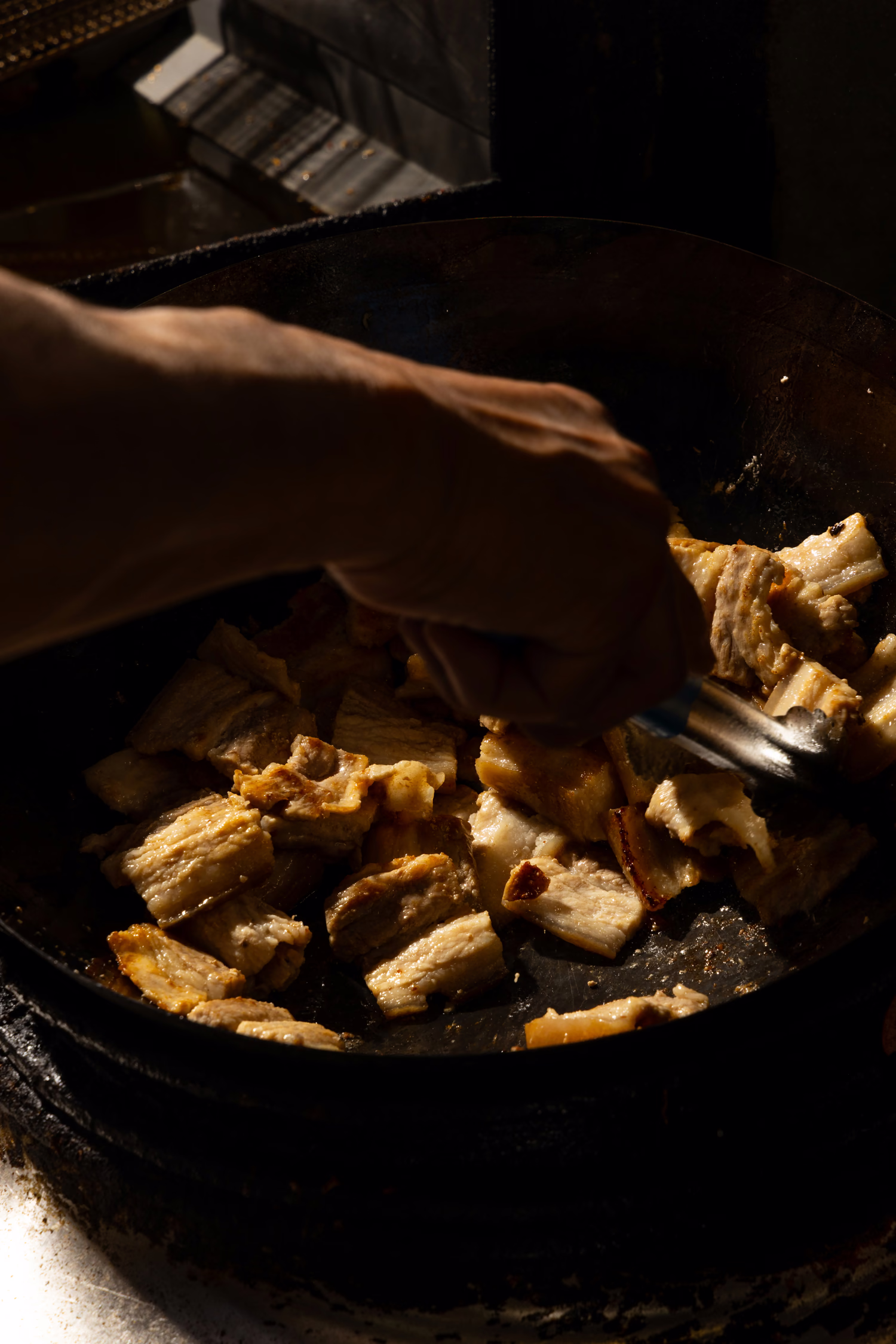 A cook stir-frying in a hot wok at Dumpling Factory