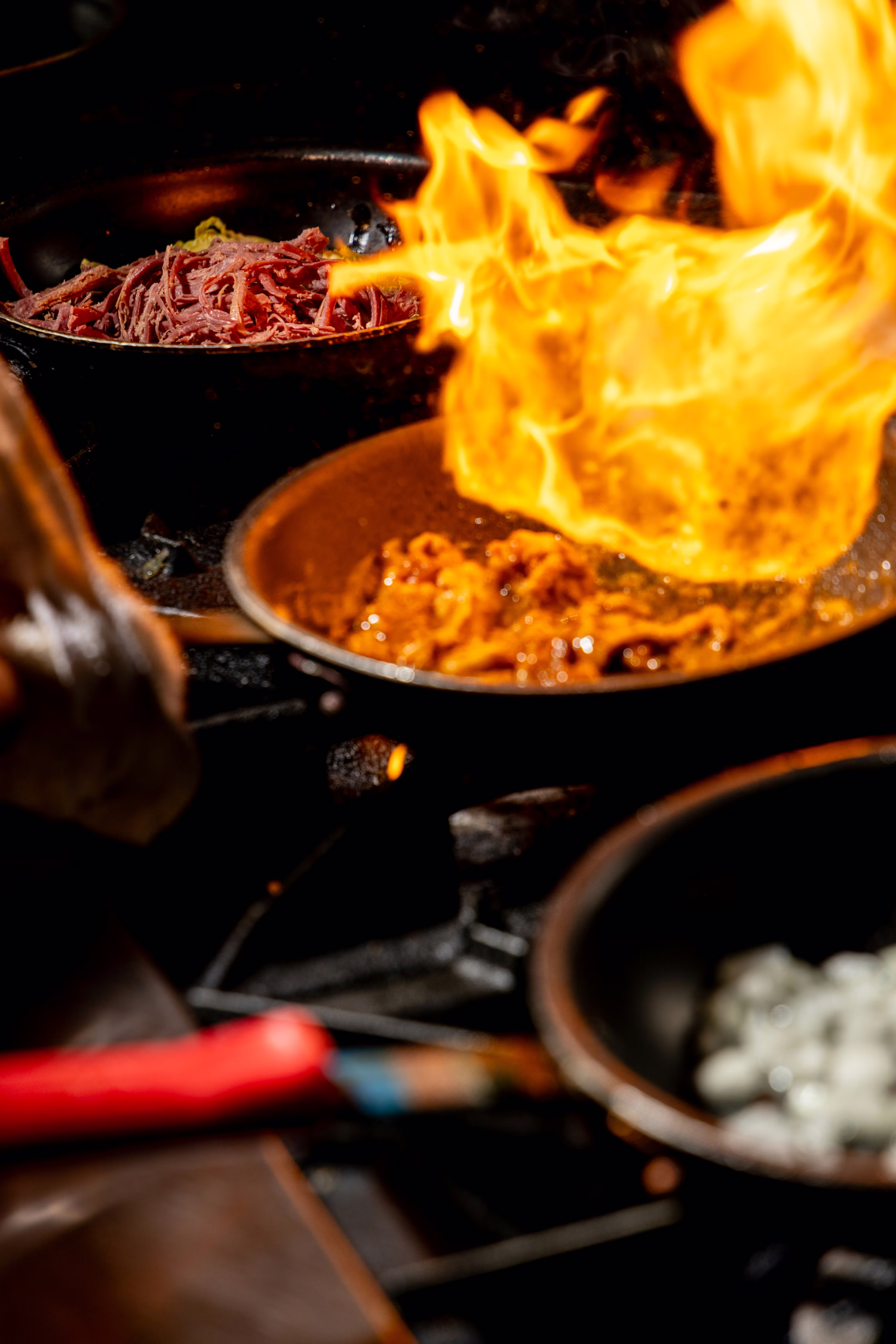 Flames rising from a pan on the kitchen line at Dime Store
