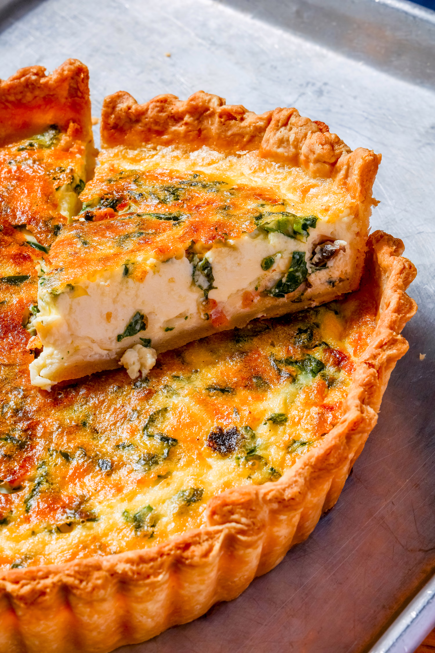 A slice lifted from a quiche with greens at Dime Store