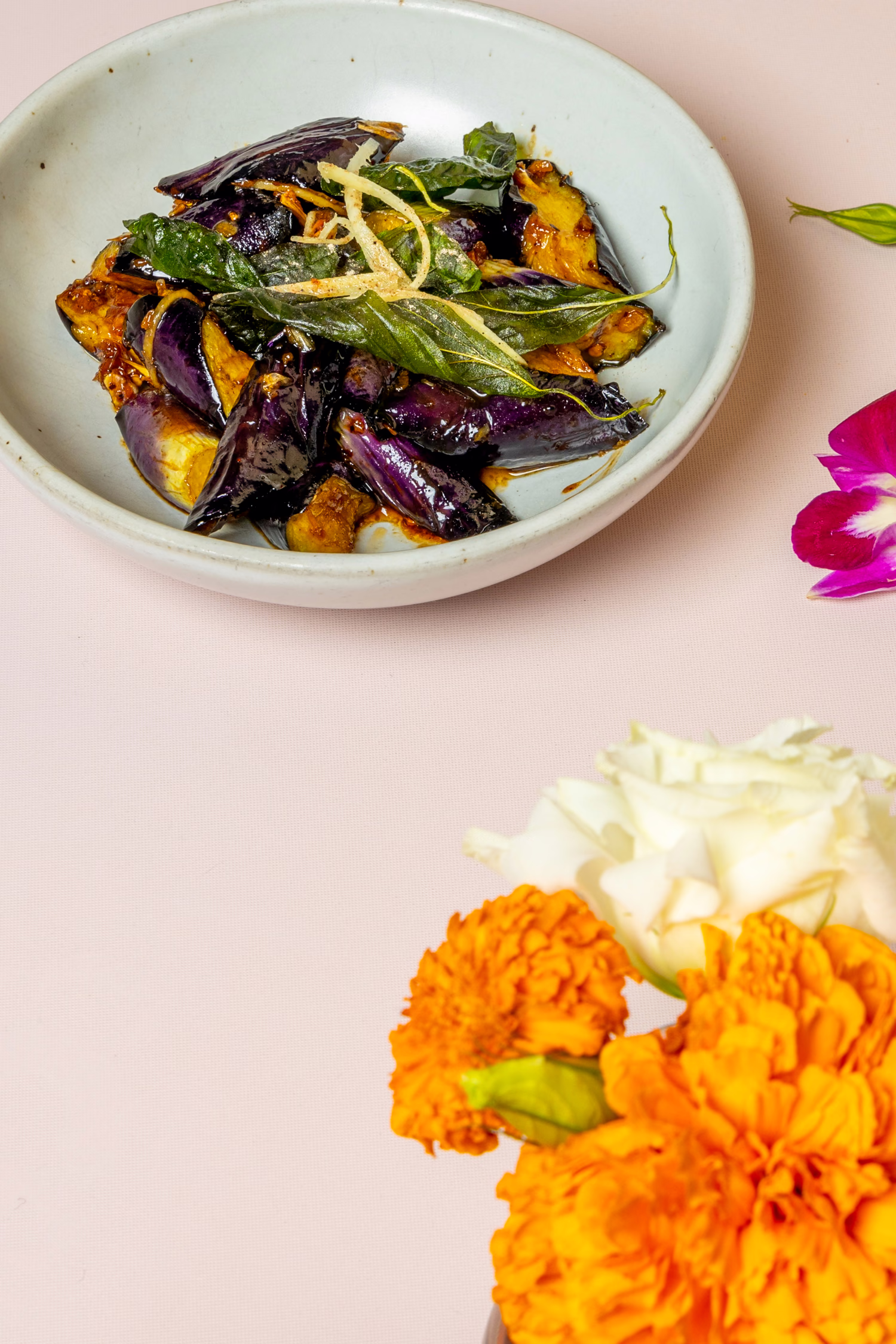 Stir-fried eggplant with basil beside marigolds at Jo's Modern Thai