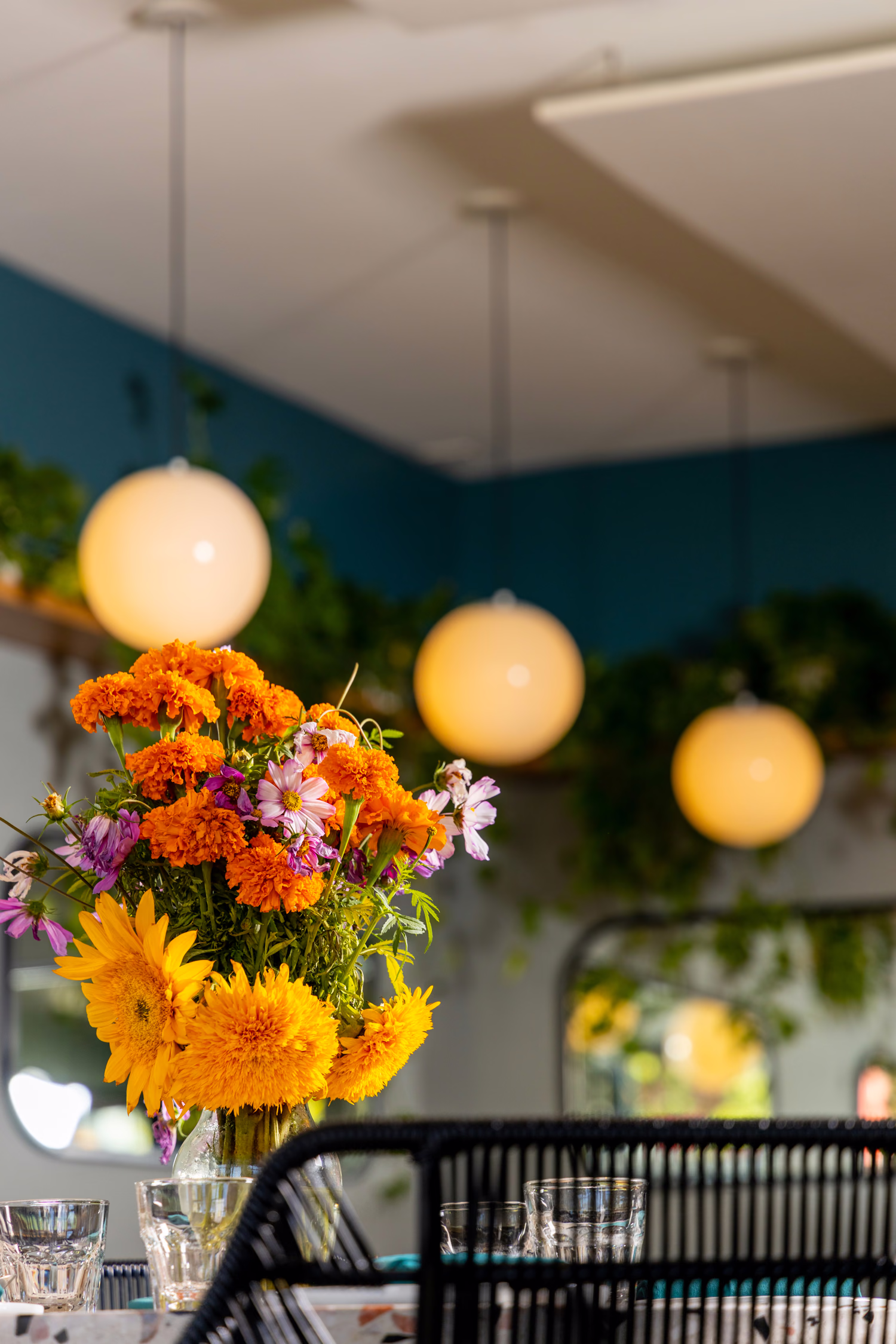 Marigolds and sunflowers under globe pendant lights at Jo's Modern Thai