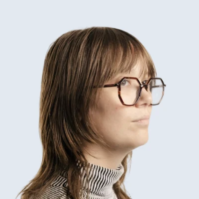 Side profile of a person with a bob haircut and glasses.