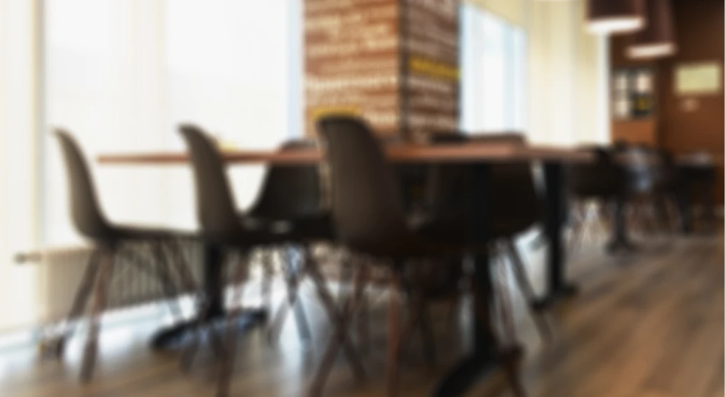 Soft-focus view of tables and chairs in a lounge.
