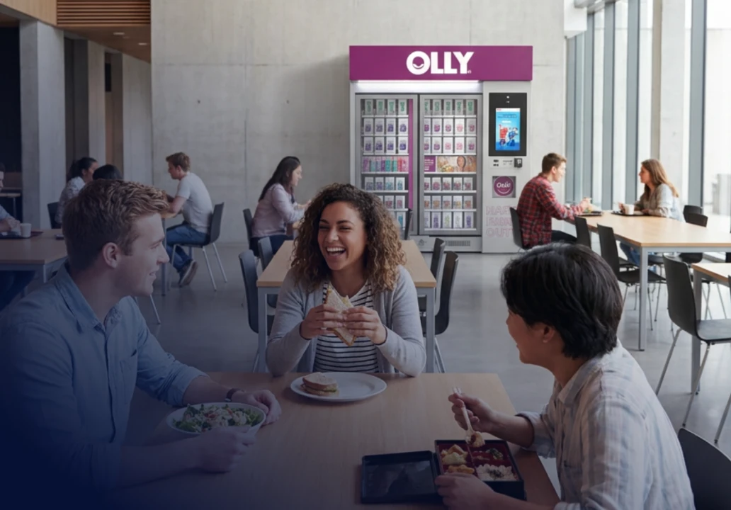 Students gathered at tables near an OLLY kiosk.
