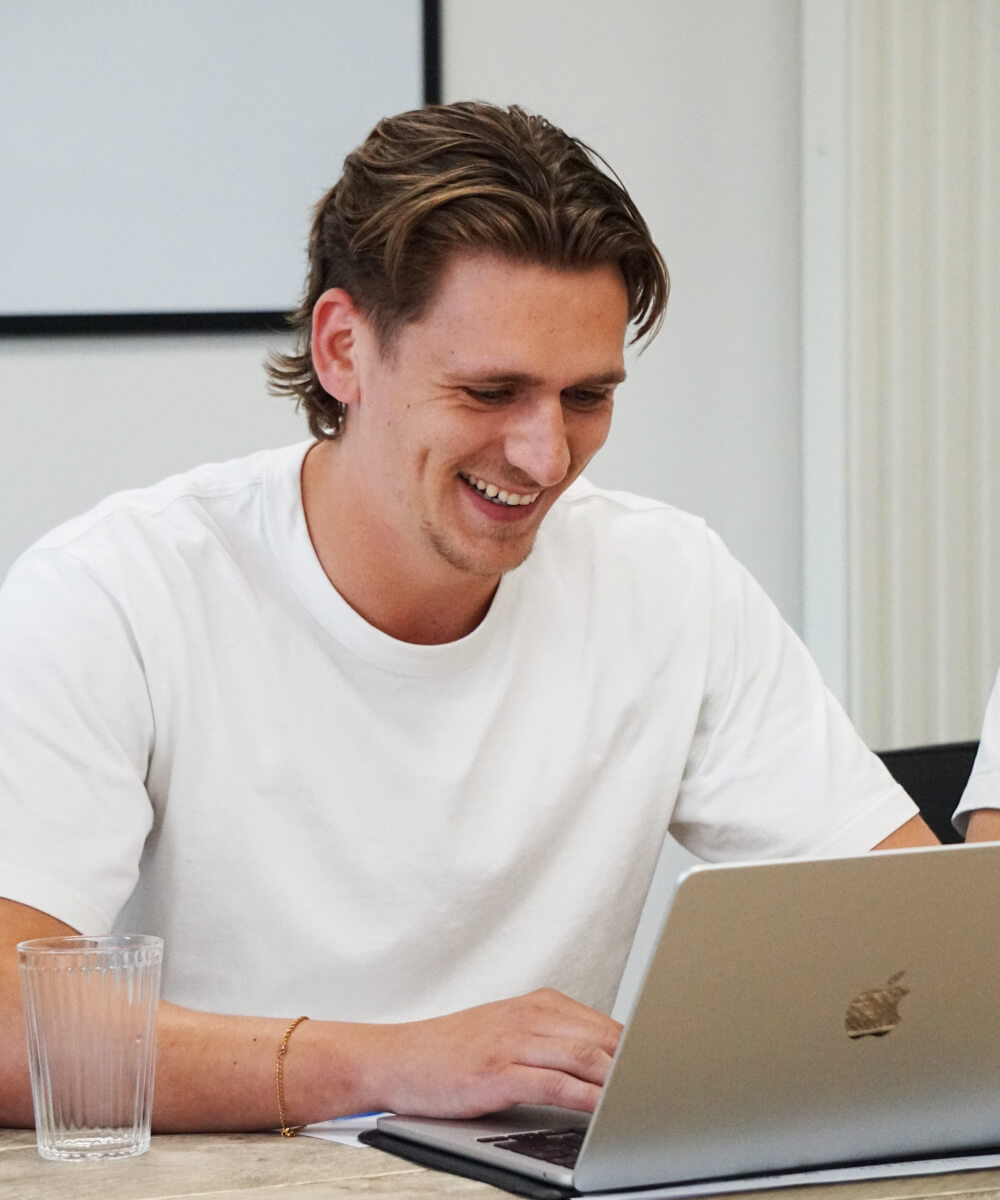 Lachend persoon achter een laptop