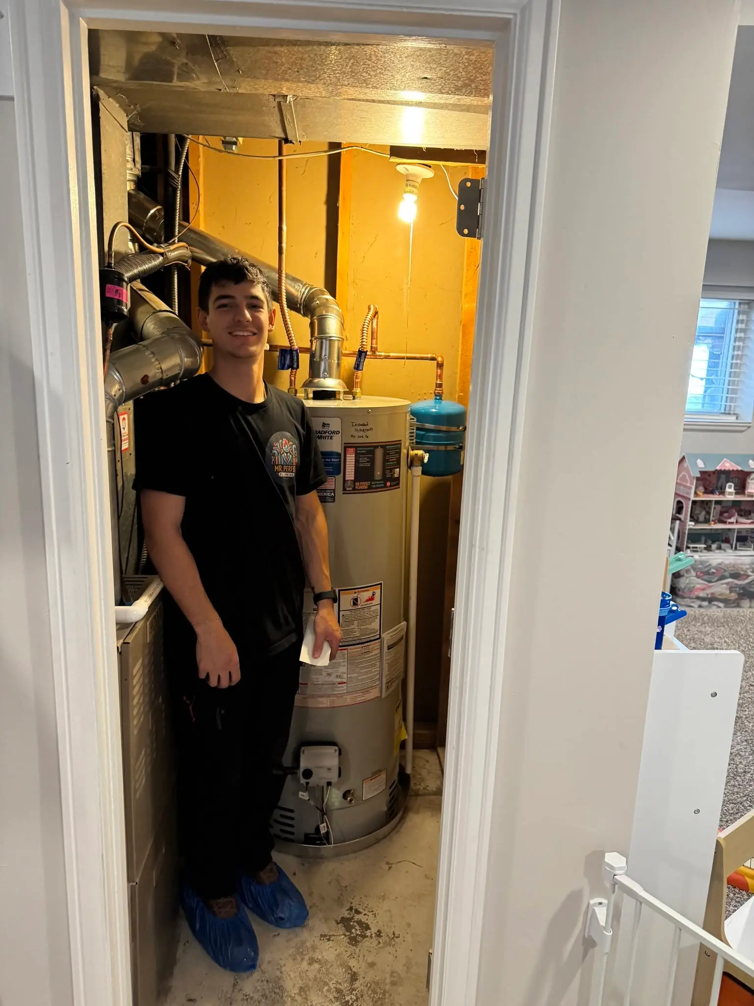 Mr. Perfect Plumbing technician standing next to a newly installed water heater
