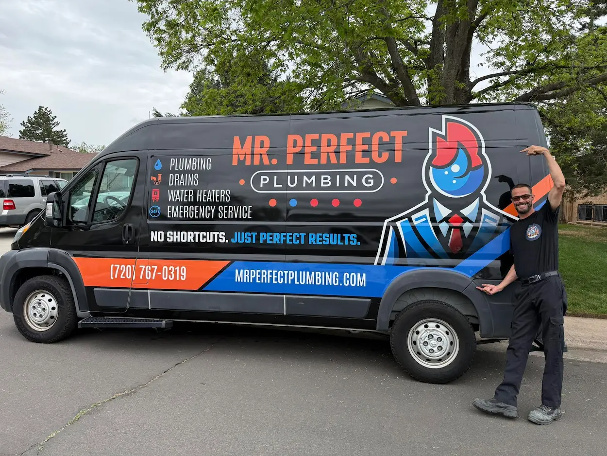 Mr. Perfect Plumbing technician standing next to the branded service van