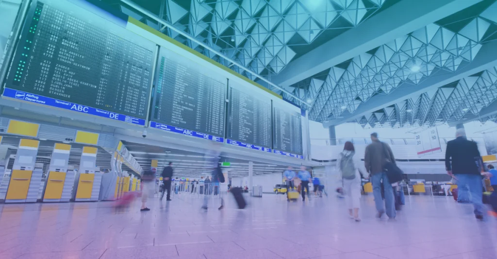 Travellers walking through a busy airport departures hall