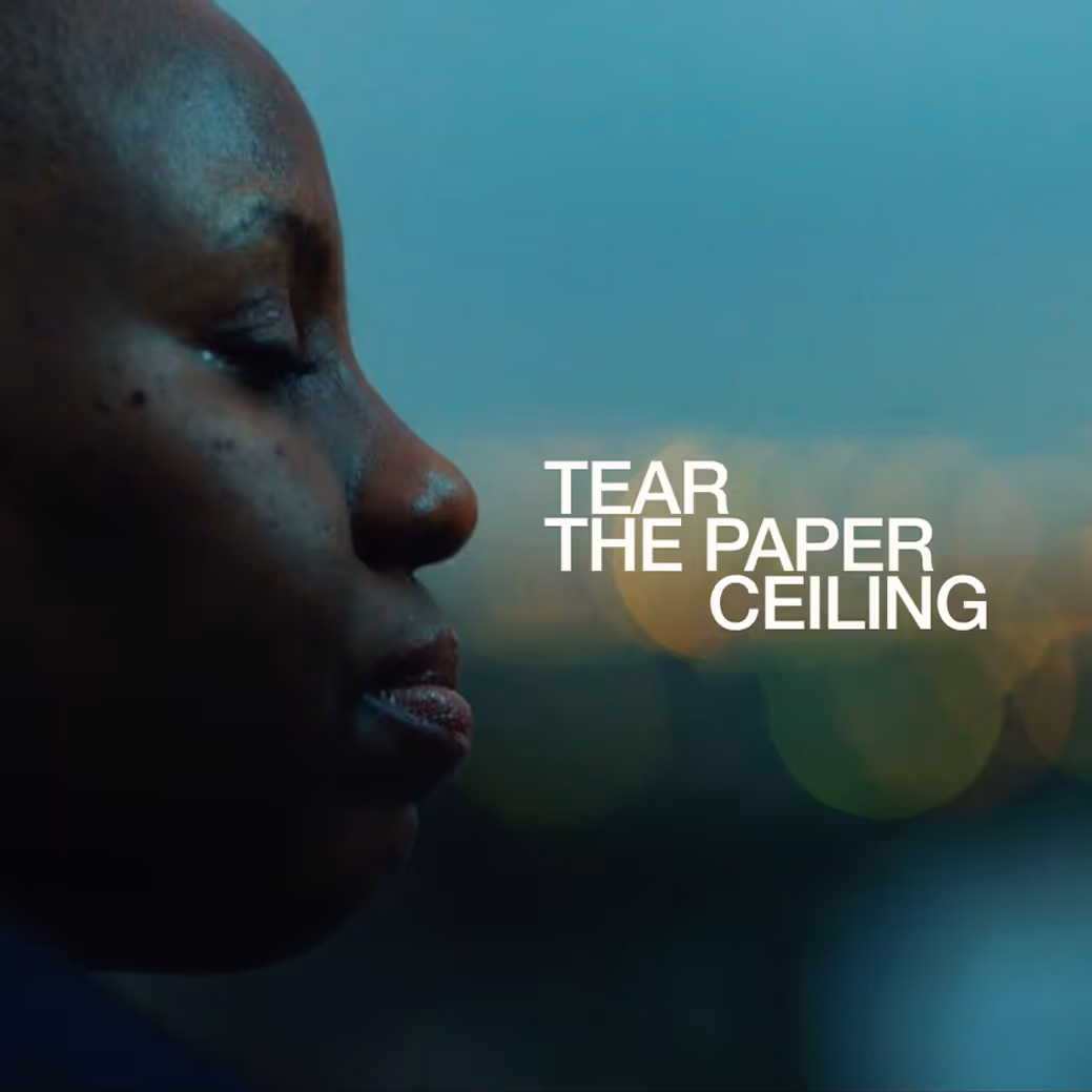 Side profile of a person with eyes closed and the text 'TEAR THE PAPER CEILING' on a blurred background.