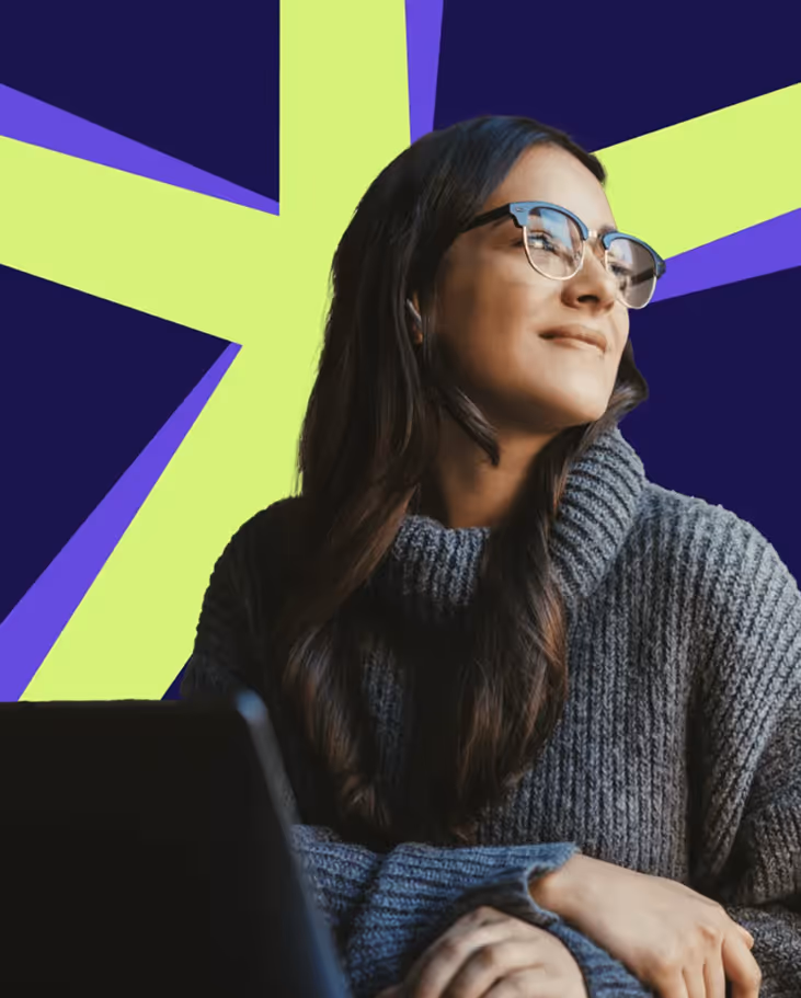 Woman with long dark hair and glasses wearing a gray sweater looking thoughtfully to the side against a vibrant abstract background.