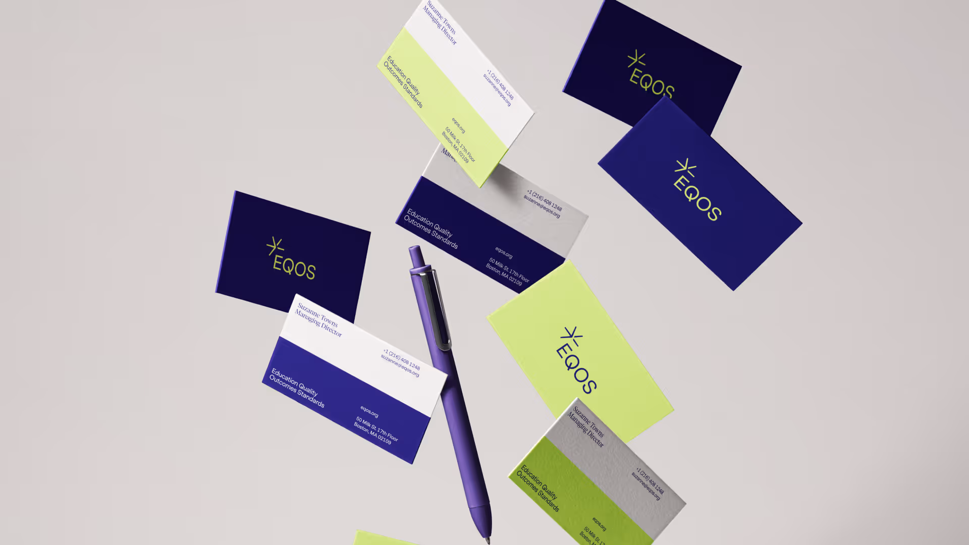 Scattered business cards featuring EQOS branding in navy and lime green alongside a purple pen on a light background.