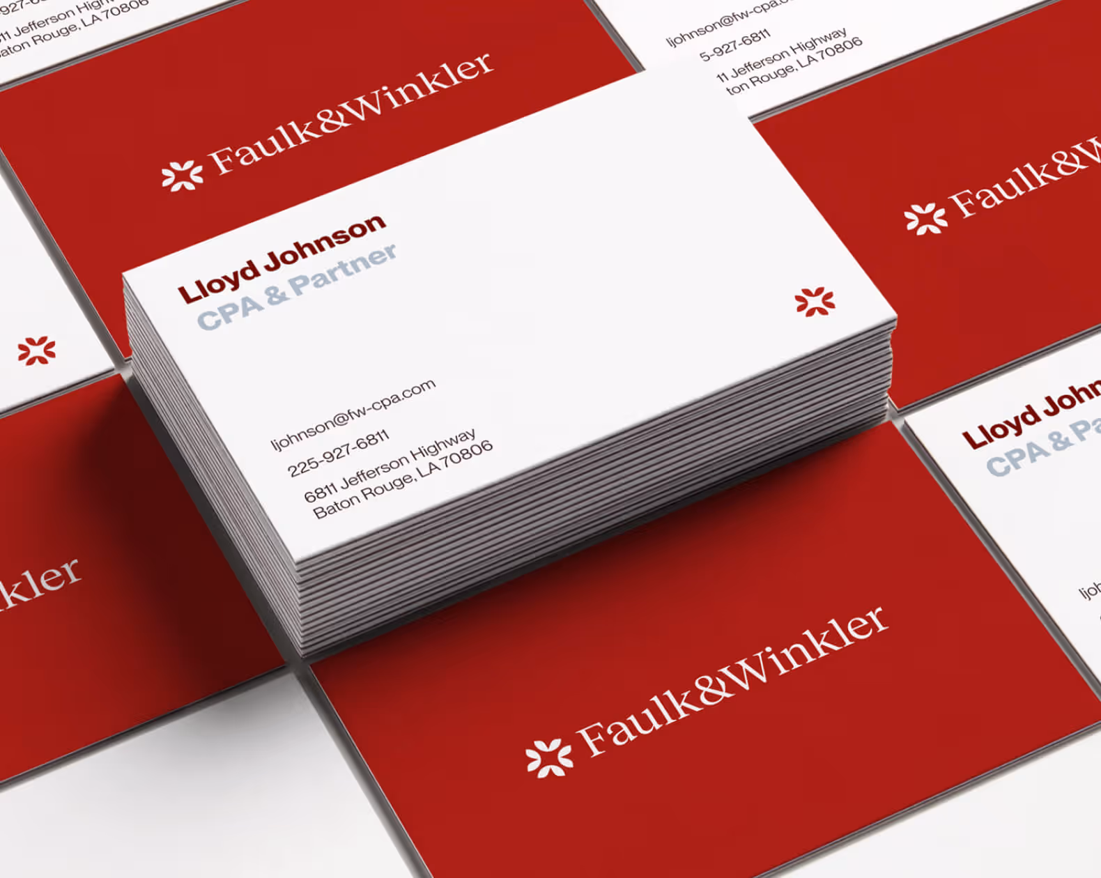 Stack of Faulk & Winkler business cards with Lloyd Johnson, CPA & Partner, contact details on white cards and red cards with company name.