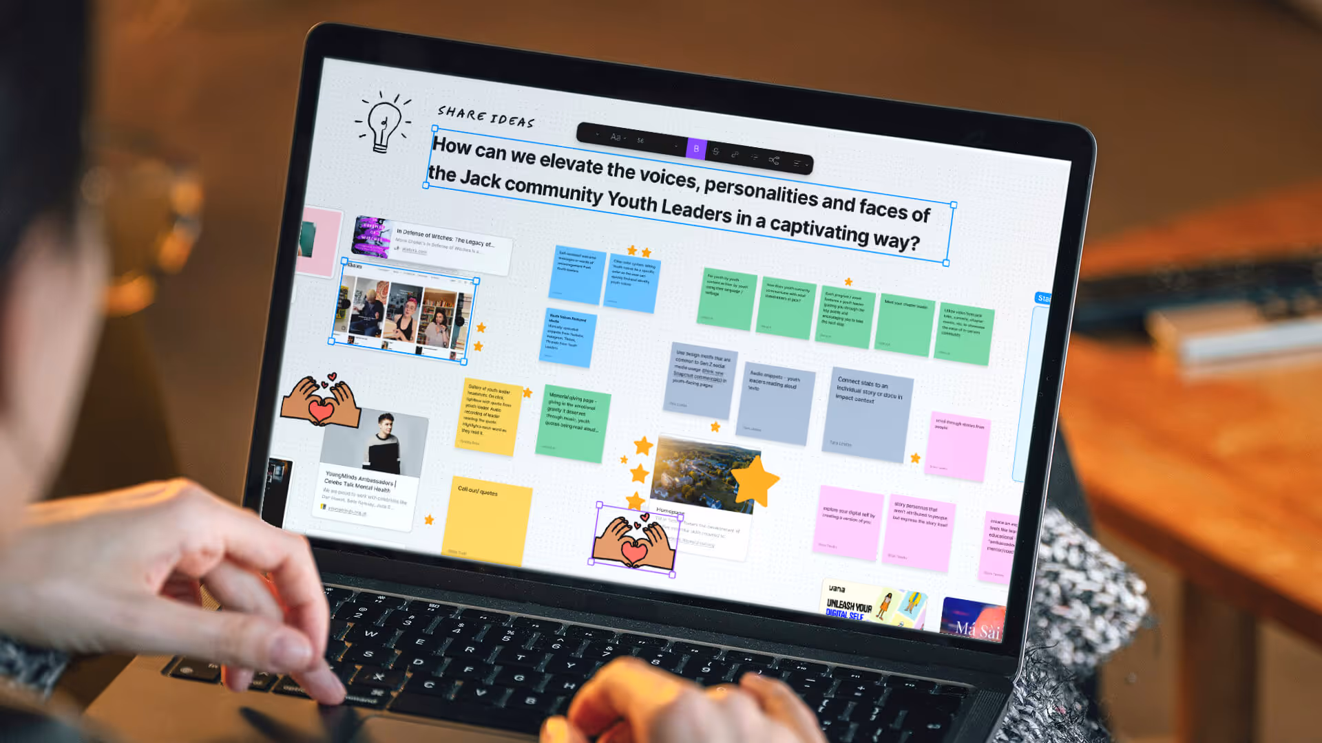 Person using a laptop displaying a digital brainstorming board titled 'How can we elevate the voices, personalities and faces of the Jack community Youth Leaders in a captivating way?' with notes, images, and icons.