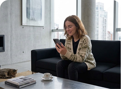 Mujer en su casa mirando el celular