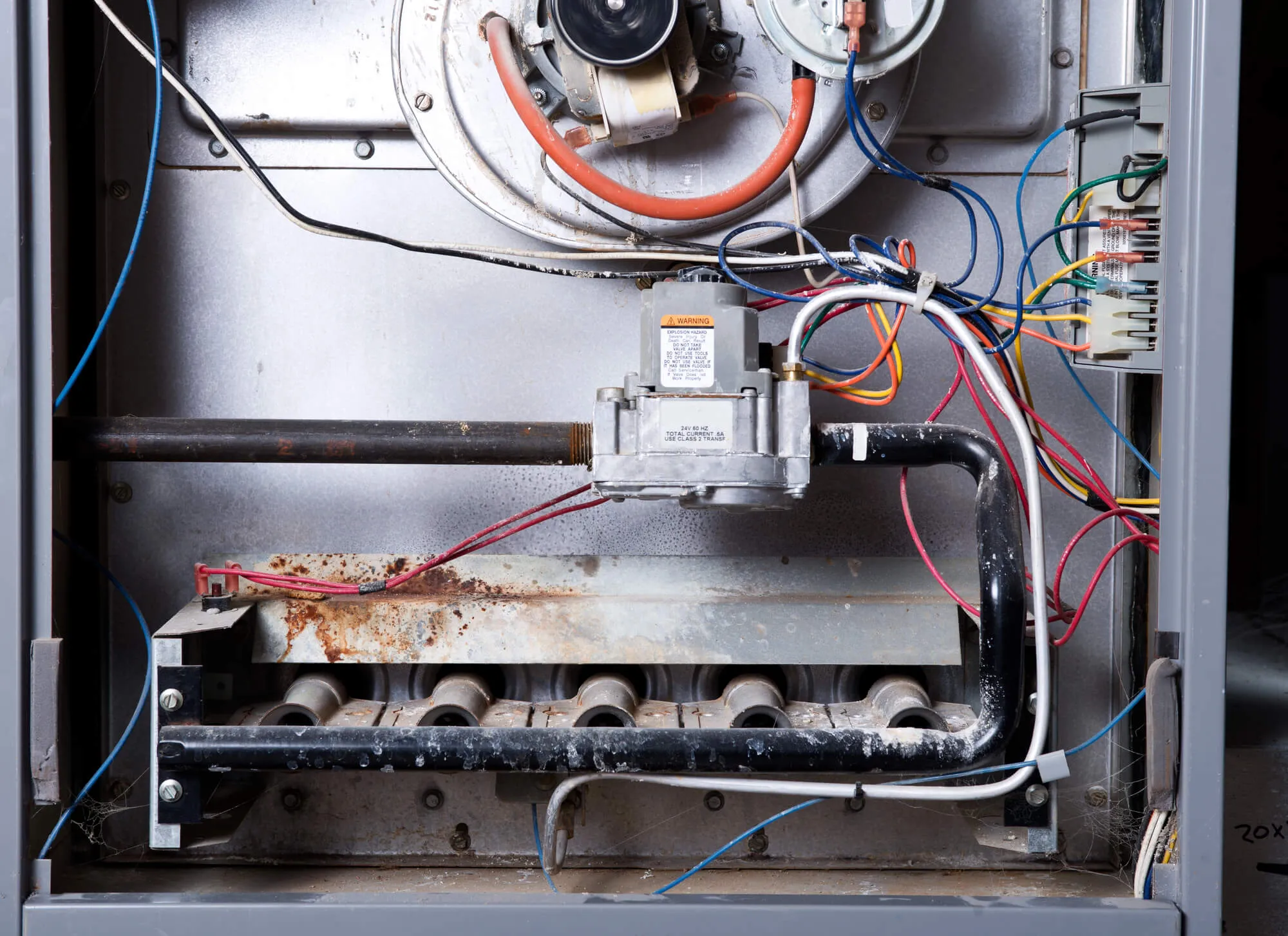 Open furnace cabinet showing the burners and gas valve