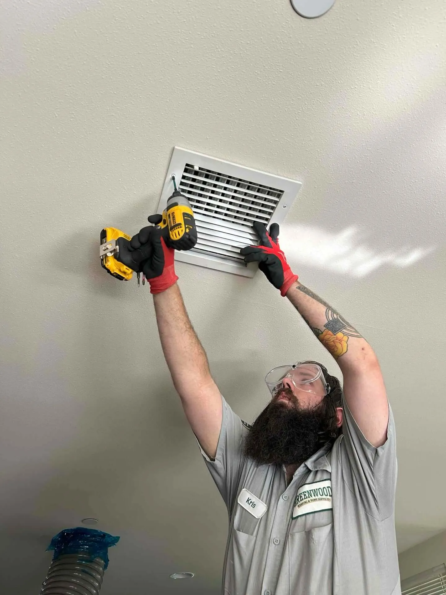 Greenwood technician cleaning a ceiling air vent