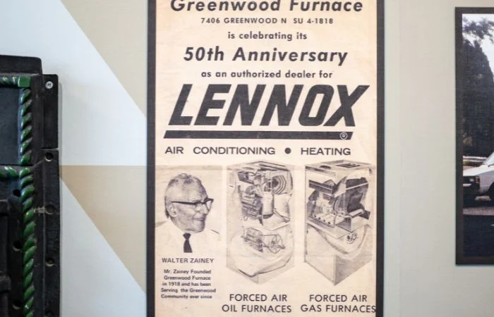 A vintage advertisement for Greenwood Furnace celebrating its 50th anniversary as an authorized dealer for Lennox, featuring portraits of Walter Zainey and illustrations of forced air oil and gas furnaces for air conditioning and heating.
