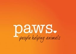 PAWS logo with the word 'paws' in white lowercase letters on an orange background, including a heart shape and the phrase 'people helping animals' below in black script.